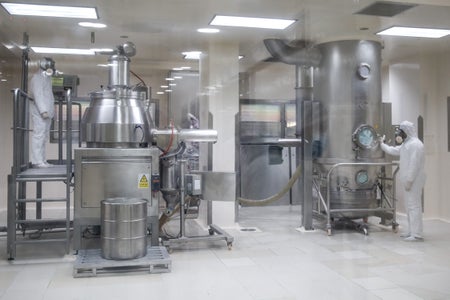 Two lab techs in a drug production facility