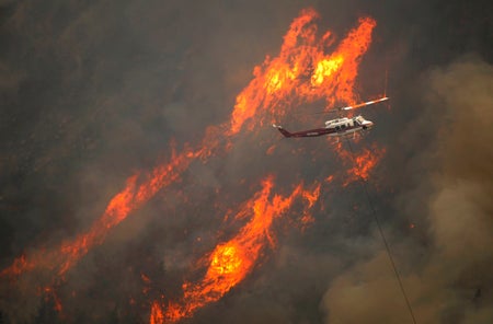 A helicopter flew through the Cache La Poudre Canyon as flames scored the forest south of the river.