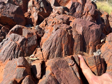 A hand touching shatter cones in ancient rocks of the Pilbara, Western Australia.