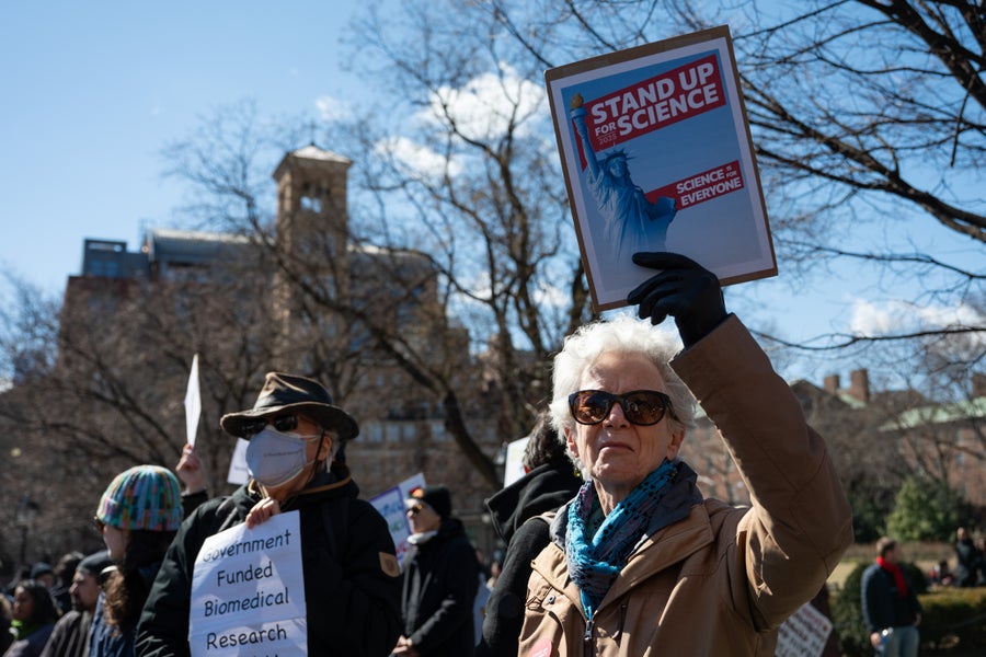 People hold signs as they gather for "Stand Up For Science" rally to protest the Trump administration's recent cuts to federal scientific funding, at Washington Square Park, New York, U.S., March 7, 2025.