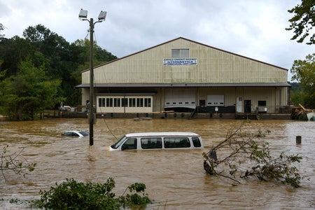 Car submerged in floodwater in front of Community building.