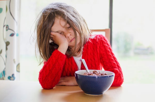 Tired girl at breakfast table